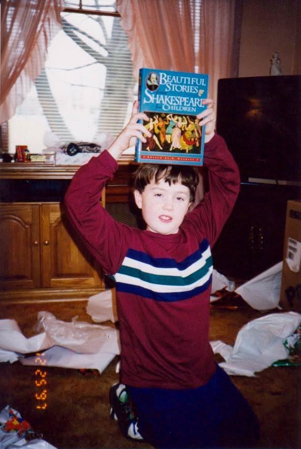 On Christmas morning, holding up a copy of “Beautiful Stories from Shakespeare for Children”