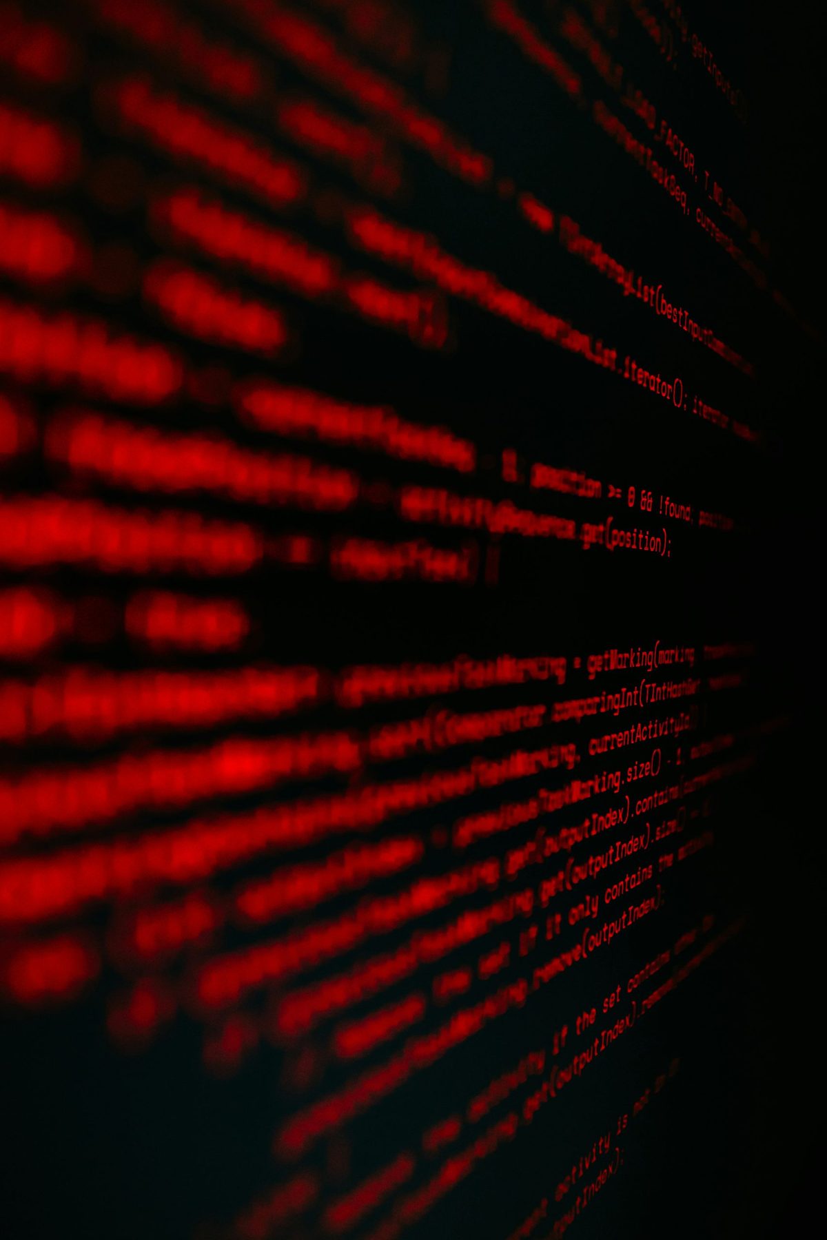 Photograph of rows of red characters glowing against a black field, receding into the dark like text on a screen.