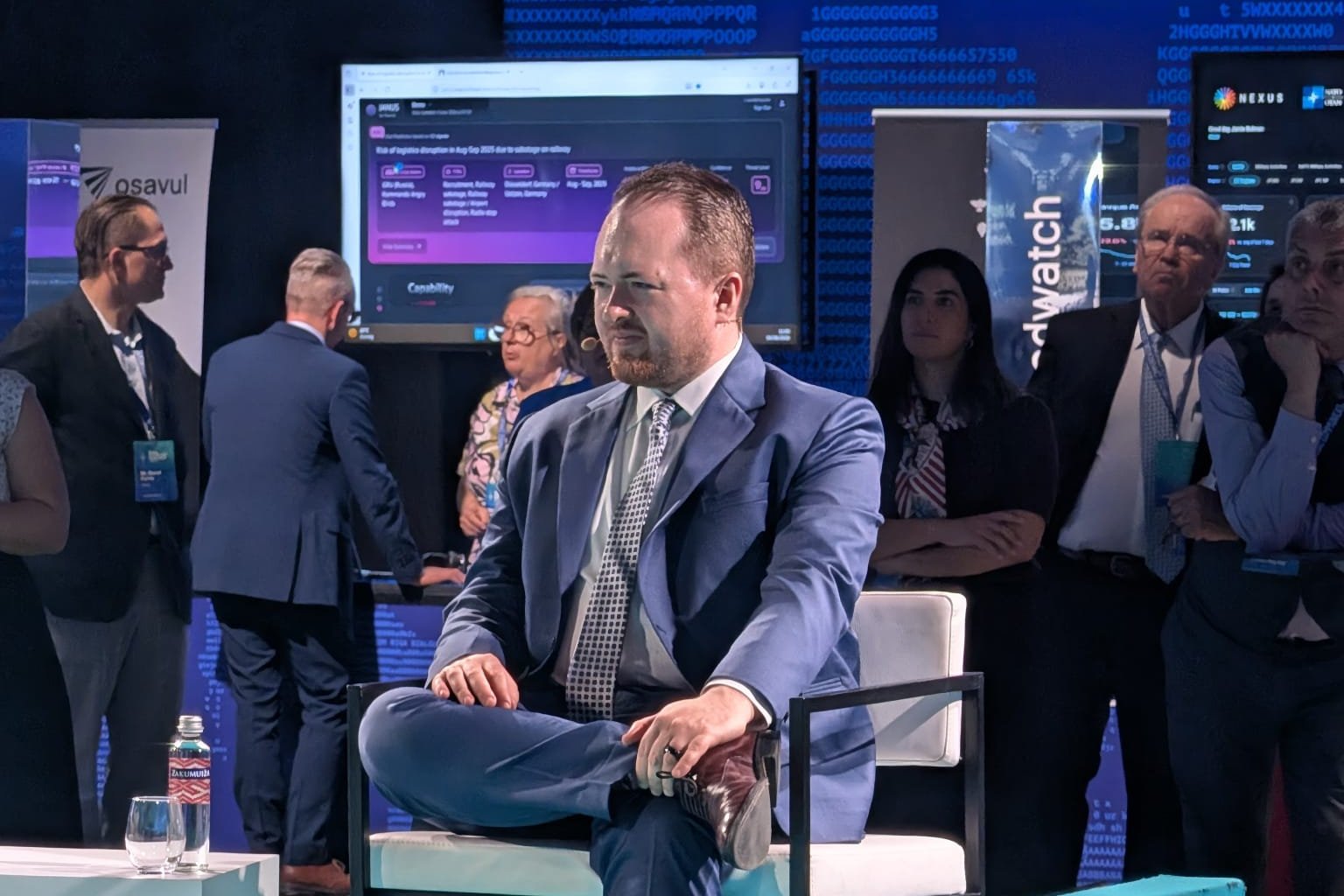 Seated on the teal stage at the Riga StratCom Dialogue, a disinformation-tracking dashboard on the screen behind