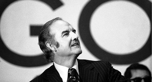 Black-and-white photo of George McGovern speaking, with a large campaign sign reading "GO" behind him.