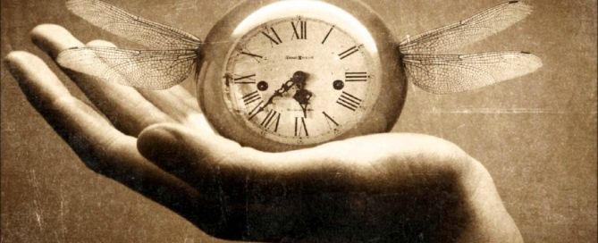Sepia photo illustration of a hand holding an antique pocket watch with dragonfly wings attached to it.